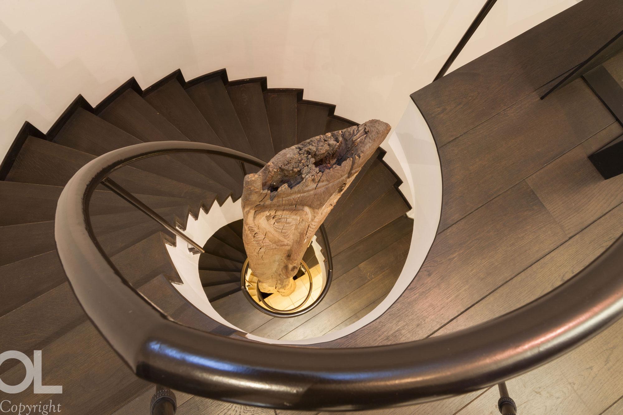 Dark wood staircase with reclaimed wood sculpture